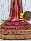Gajari and maroon color bandhej silk saree with zari weaving work