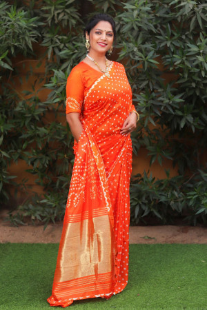 Orange color pure bandhej silk saree with zari weaving work