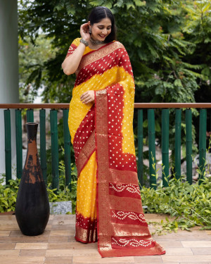 Yellow and maroon color bandhej silk saree with zari weaving work