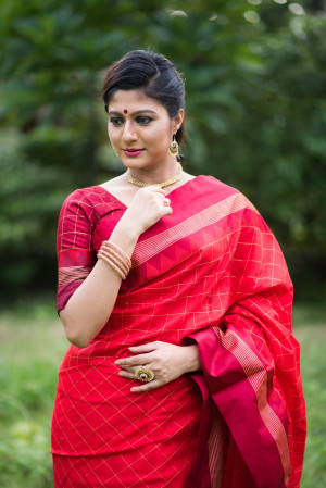 Red color soft raw silk saree with zari woven work
