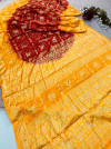 Red and yellow hand bandhej silk saree with zari weaving work