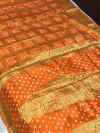 Orange color pure hand bandhej silk saree with zari weaving work