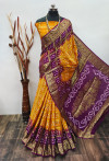 Yellow and magenta color hand bandhej silk saree with zari weaving work