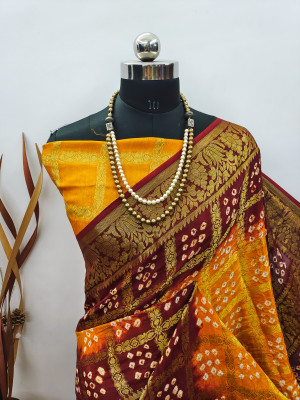 Yellow and maroon color hand bandhej silk saree with zari weaving work