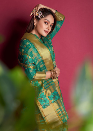 Green color organza silk saree with embroidered and zari weaving work
