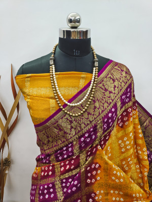 Yellow and magenta color hand bandhej silk saree with zari weaving work