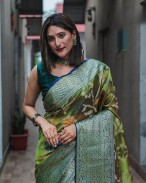 Mahendi green color organza silk saree with woven design